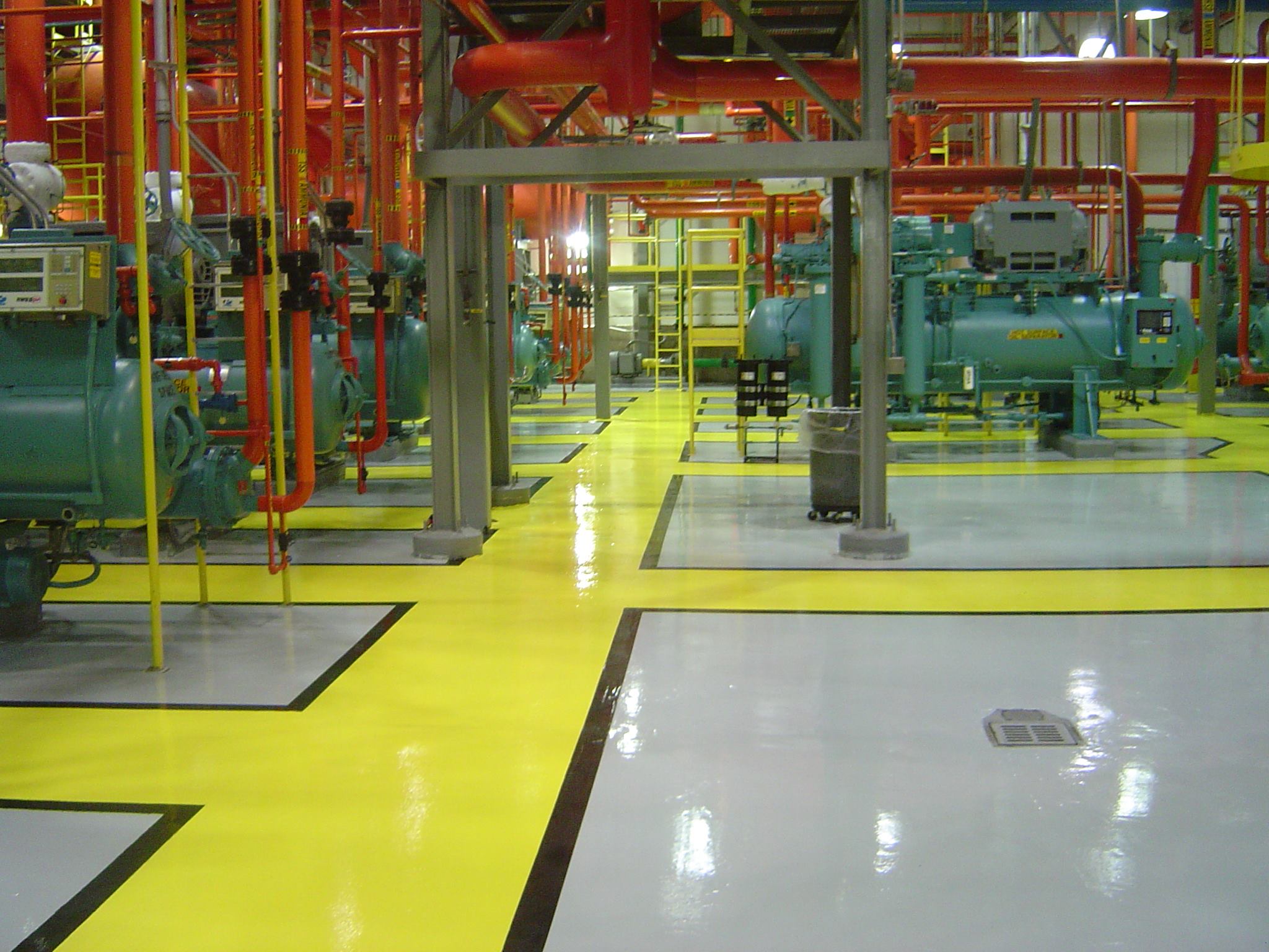 Commercial epoxy flooring with safety line striping in industrial compressor room