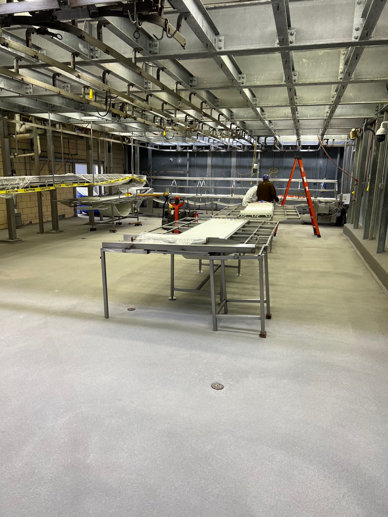 Completed seamless gray floor with proper drainage slope and floor drain in food processing facility