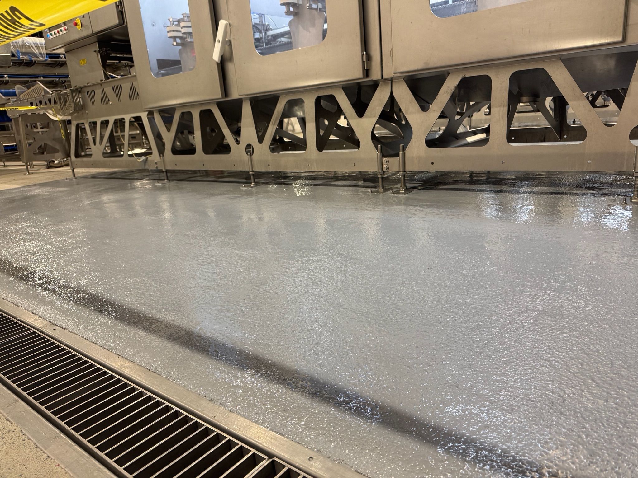 Close-up of STX floor under equipment legs with sealed surface and trench drain integration