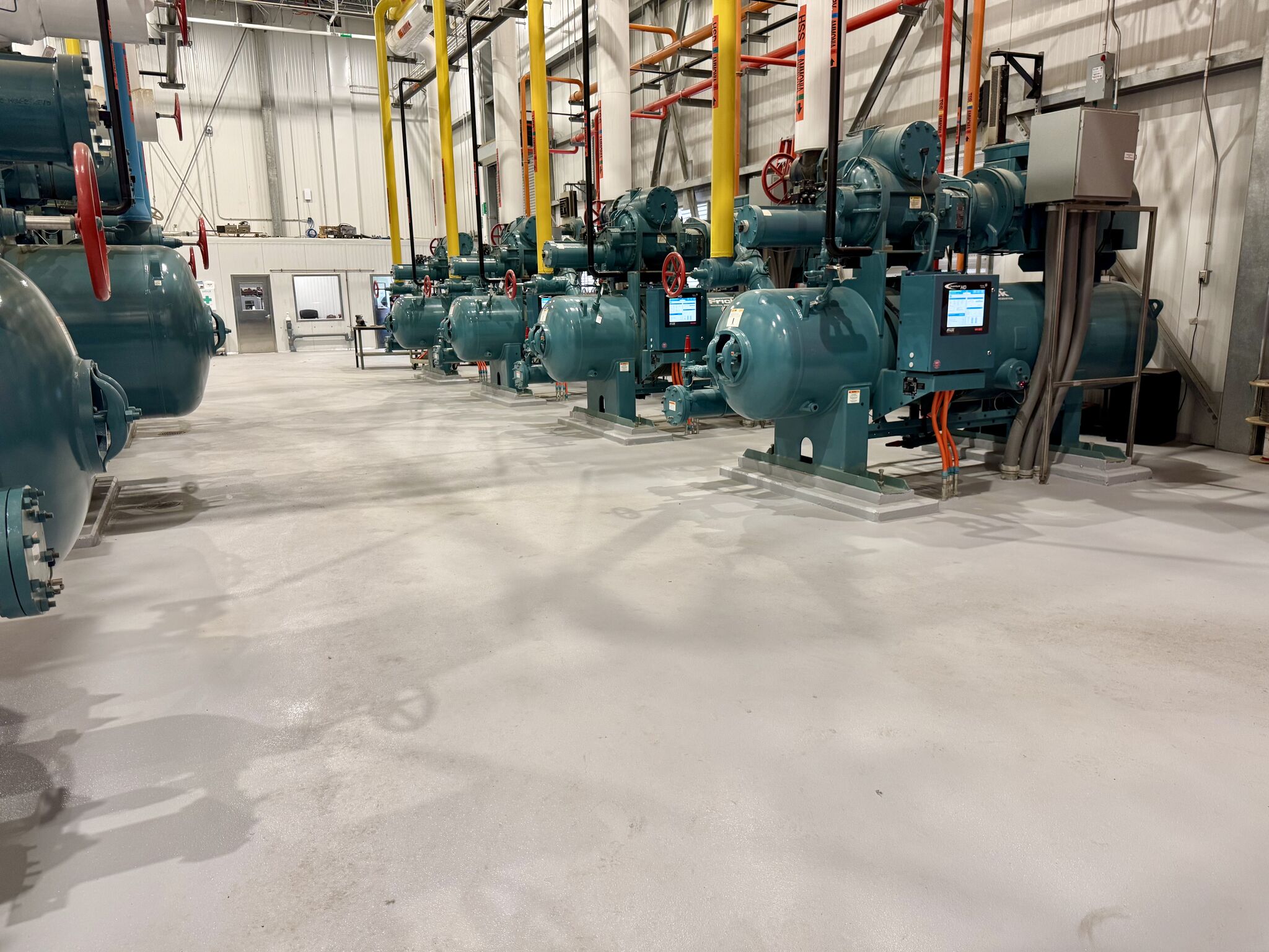 Along the compressor row — clean, bright floor with no cracks, delamination, or water pooling