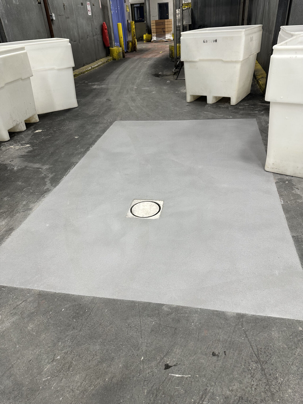 Completed SaniCrete STX floor section with drain integration and white bins