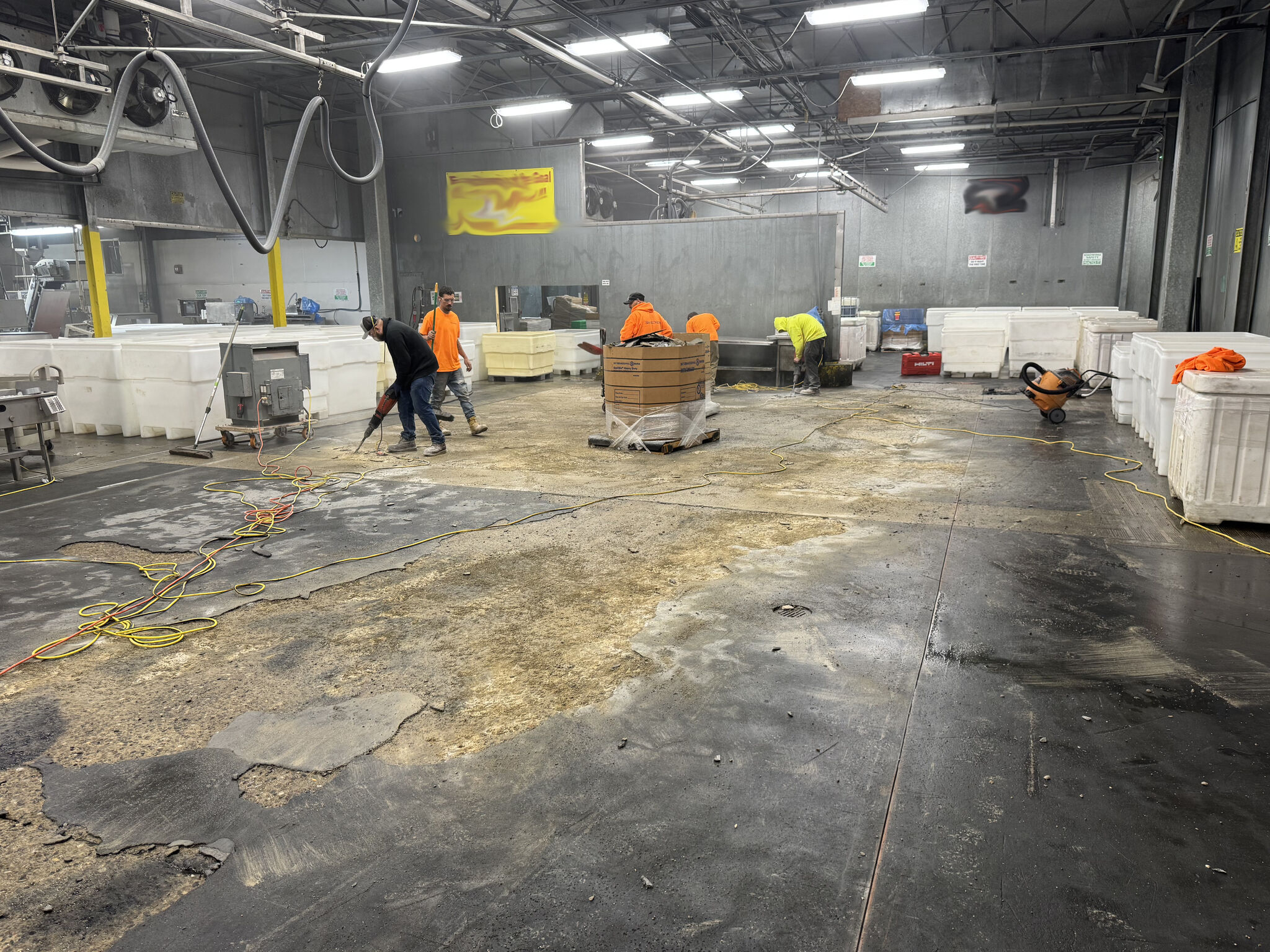 SaniCrete crew in orange shirts demolishing and prepping the production floor