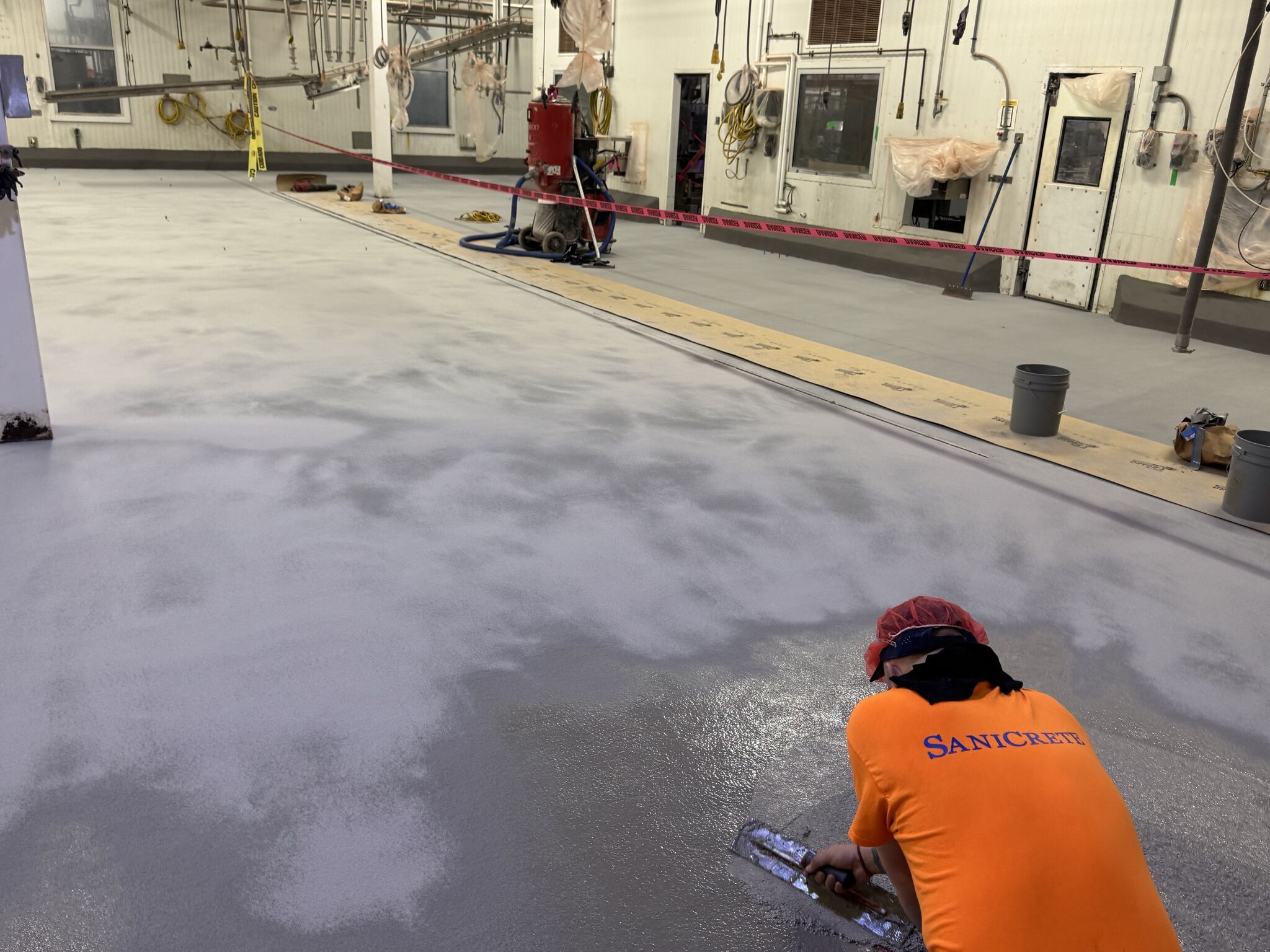 SaniCrete crew member troweling fresh SaniCrete STX cementitious urethane in food processing facility