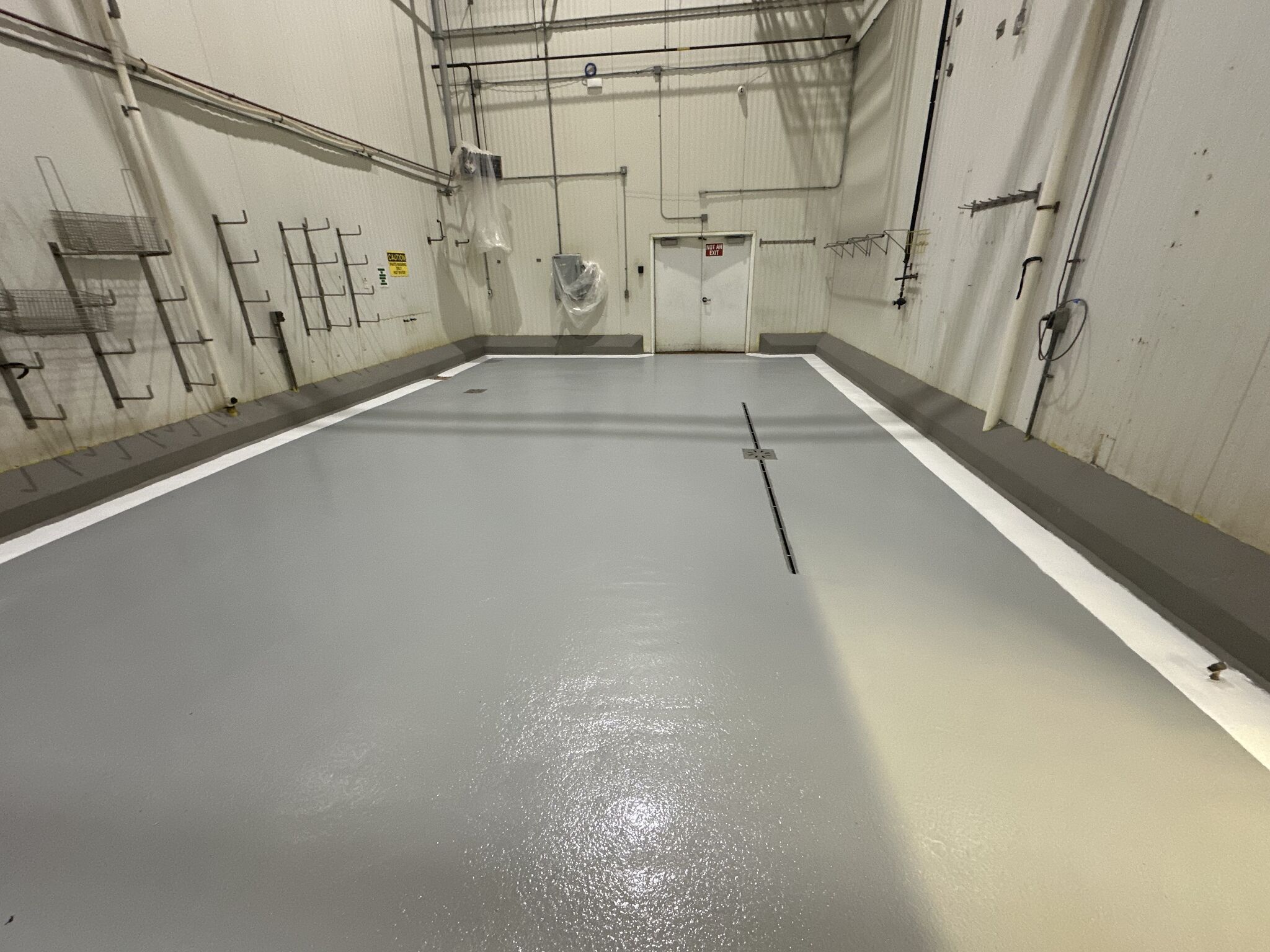 Completed chemical room floor with SaniCrete STX and white line striping