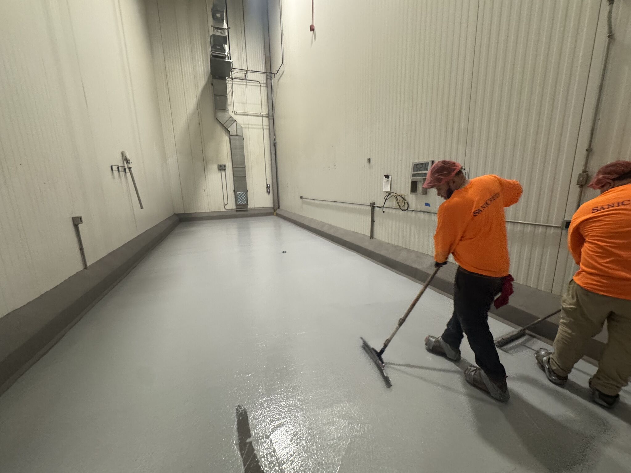 SaniCrete crew member rolling out topcoat in spice room
